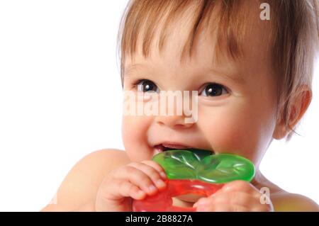 Un petit bébé d'un an tient à portée de main un jouet coloré de dentition. Jouet de dents d'enfant. Portrait sur fond blanc isolé Banque D'Images