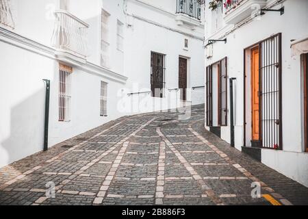 Murs traditionnels blancs et trottoirs de rue piétonne en Andalousie Espagne - Vejer de la Frontera Banque D'Images