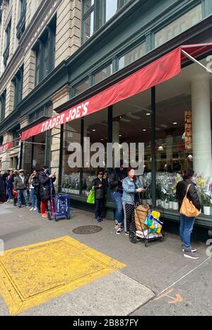 NEW YORK, NY - 30 MARS: La ligne se formant à l'extérieur de Trader JoeÕs à Chelsea après que le gouverneur NYÕs Cuomo a mis en place une politique de travail à 100% à domicile pour lutter contre la propagation du Coronavirus le 20 mars 2020 à ne York City. Crédit: Rainmaker photo/MediaPunch Banque D'Images