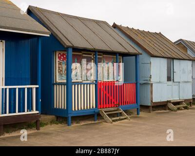 Des cabanes de plage le long de la promenade entre Sandilands et Sutton on Sea, Lincolnshire, Royaume-Uni Banque D'Images