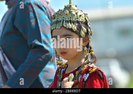 TURKMÉNISTAN, ASHGABAT - 1 MAI 2019 : jour de raceHorse turkmène. Public. Fille dans un vêtement traditionnel et la décoration de tête. Banque D'Images