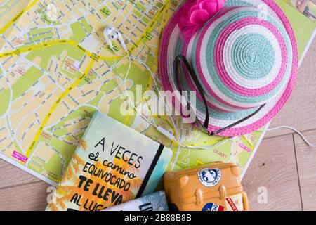 La carte, la valise, le chapeau rose, les lunettes et les écouteurs pour le téléphone sont nécessaires pour un voyage d'été en Espagne. Banque D'Images