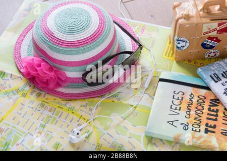 La carte, la valise, le chapeau rose, les lunettes et les écouteurs pour le téléphone sont nécessaires pour un voyage d'été en Espagne. Banque D'Images