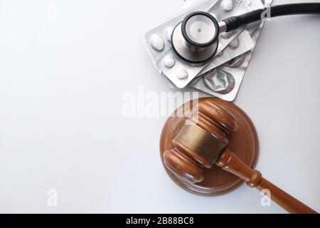 Vue de dessus du juge gavel et stéthoscope avec pilules sur table Banque D'Images