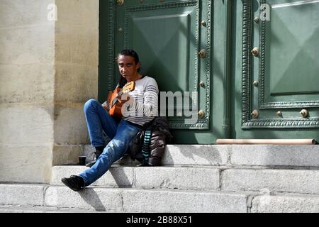 Homme jouant de la guitare sur les marches du théâtre de Béziers dans la région occitanie du Sud de la France Banque D'Images