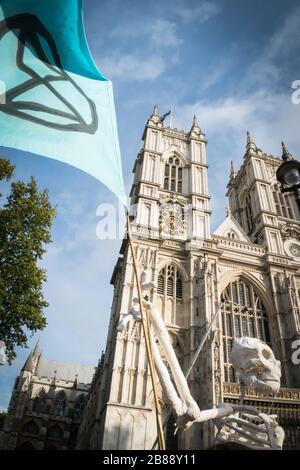 Westminster Abbey, Londres, Royaume-Uni - 9 octobre 2019 - les totêtes de l'extinction des changements climatiques - un faux squelette avec un drapeau des manifestants Banque D'Images