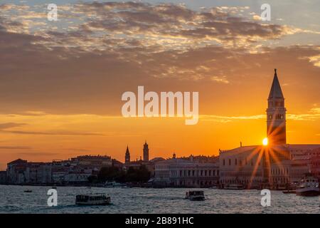 Coucher de soleil coloré au-dessus du centre historique de Venise, en Italie, avec rayons du soleil filtrant du Campanile de San Marco au-dessus du Palais des Doges Banque D'Images