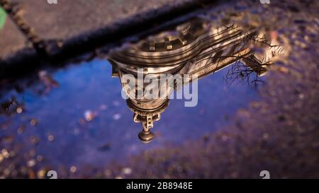 Réflexions dans des flaques ou des lacs de bâtiments, de bateaux ou d'arbres et de lampes de rue. Banque D'Images