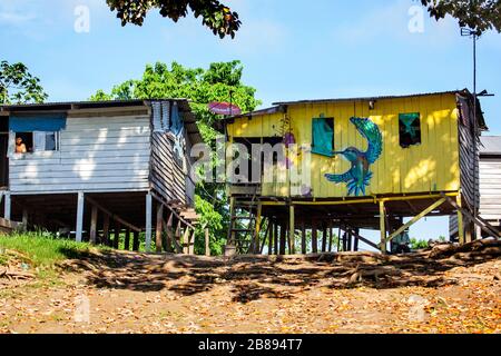 Maison bâtie indienne sur la rive de la rivière Amazone, de l'autre côté du port de Leticia Colombie au Pérou, en Amérique du Sud. Banque D'Images