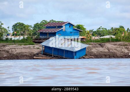 Maisons flottantes sur les rives de la rivière Amazone, le Pérou et la Colombie frontière, Amérique du Sud. Banque D'Images