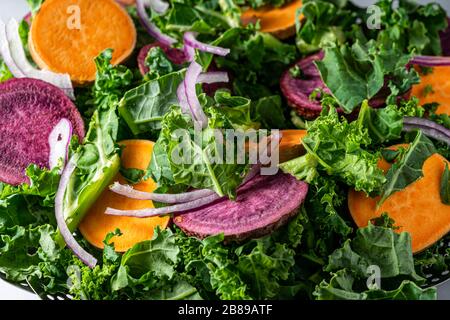 Tranches de patates douces et kale dans un pot à vapeur. Banque D'Images