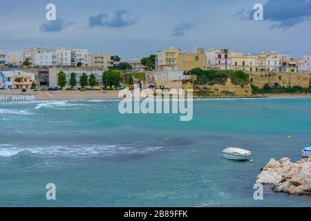 Mélancolique, belle, nuageux jour à Otranto, Puglia, Italie. Vue imprenable sur la ville antique avec des maisons jaunes et blanches, ciel gris foncé, eau bleue Banque D'Images