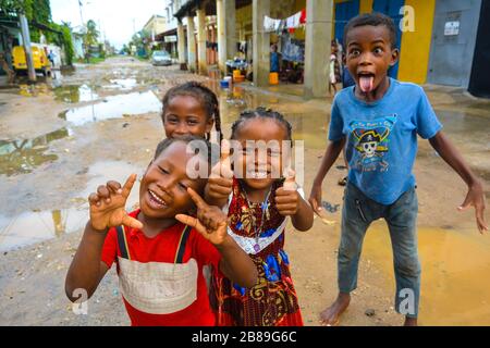 Majunga, Madagascar, Afrique, 02/22/20 : de beaux gosses noires africaines joyeuses. Les garçons et les filles malgaches sourient, montrent les pouces vers le haut et montrent la langue. Route de terre Banque D'Images