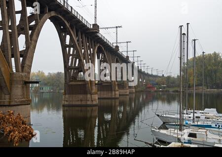 Le pont ferroviaire arqué traverse une rivière le jour de l'automne Banque D'Images