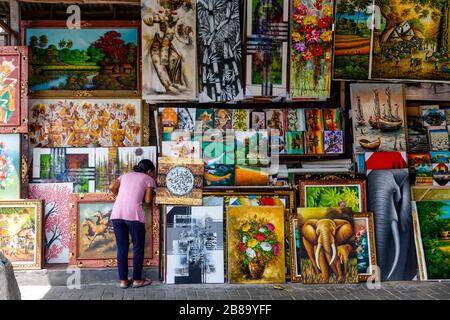 Une femme regarde l'art à vendre au marché de l'art Sukawati, Gianyar, Bali, Indonésie. Banque D'Images