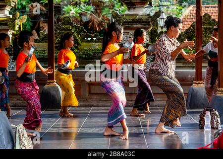 On enseigne aux jeunes filles balinaises la danse traditionnelle au Palais d'Ubud, à Ubud, à Bali, en Indonésie. Banque D'Images