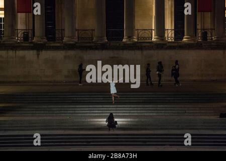 Trafalgar Square, Londres, Royaume-Uni. 21 mars 2020. Une femme pose pour une photo.Trafalgar Square juste après minuit le samedi. Le gouvernement conseille de rester à la maison et de limiter la vie sociale. Banque D'Images