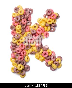 Lettre K de l'alphabet anglais à partir de flocons de couleur rose sur un fond blanc isolé. Motif alimentaire à base de céréales pour le petit-déjeuner sucré. alph brillant Banque D'Images