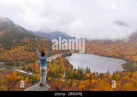 Femme se posant devant le magnifique lac Echo de Artists Bluff Loop dans le New Hampshire USA Banque D'Images