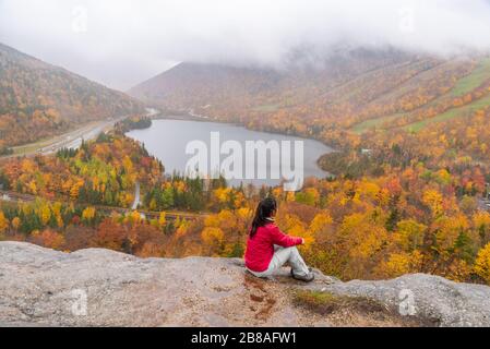 Femme se posant devant le magnifique lac Echo de Artists Bluff Loop dans le New Hampshire USA Banque D'Images