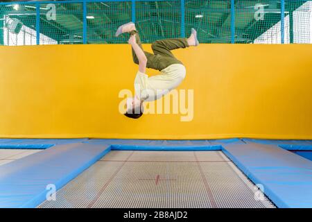 Un adolescent sautant sur le parc du trampoline dans le centre sportif Banque D'Images