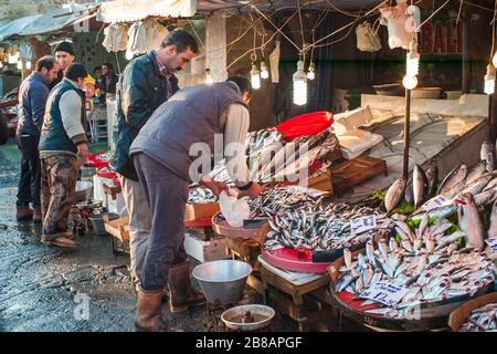 Istanbul, Turquie - 3 janvier 2012 : poissonnier turc vendant du poisson à un client sur le marché aux poissons près du pont de Galata appelé Karakoy Balik Pasari. Banque D'Images