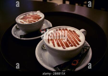 Gros plan de deux tasses de café avec des sachets de sucre la table sous les feux Banque D'Images