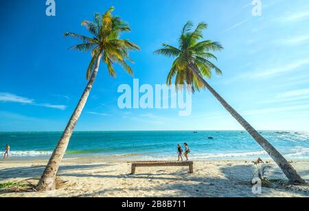 Quelques touristes étrangers font une promenade tranquille dans une belle baie l'après-midi d'été sur une plage tropicale à Mui ne, au Vietnam Banque D'Images