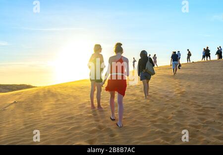 Les touristes étrangers qui connaissent la haute colline de sable doré pour regarder le coucher du soleil sur le dessus du désert en été à Mui ne, au Vietnam Banque D'Images