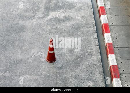 Cônes de circulation, ciment au rez-de-chaussée et cônes de circulation en plastique bandes rouges et blanches sont des équipements de sécurité sur la route Banque D'Images