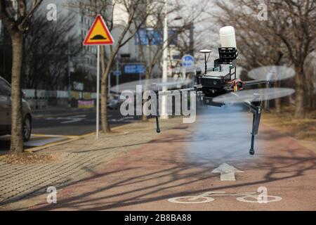 Drone vaporisant du désinfectant dans la rue de la ville pendant la pandémie de coronavirus Banque D'Images