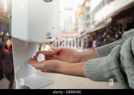 La femme traite ses mains avec un désinfectant dans un magasin alimentaire pendant l'épidémie de coronavirus Banque D'Images