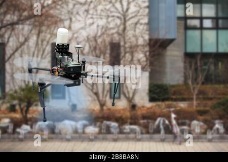 Drone vaporisant du désinfectant dans la rue de la ville pendant la pandémie de coronavirus Banque D'Images