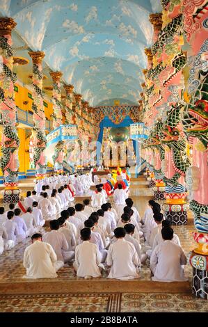 Caodaisme suiveur médidate à l'intérieur de Cao Dai Tample à Tay Ninh, au Vietnam. Banque D'Images