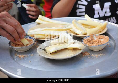 Dégustez des racines de manioc avec du sucre et des arachides écrasées Banque D'Images