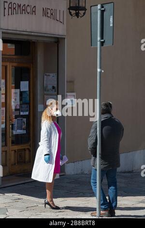 Campobasso,région de Molise,Italie:UN pharmacien médecin avec un masque de protection parle, en gardant sa distance, avec un client devant une pharmacie pendant Banque D'Images