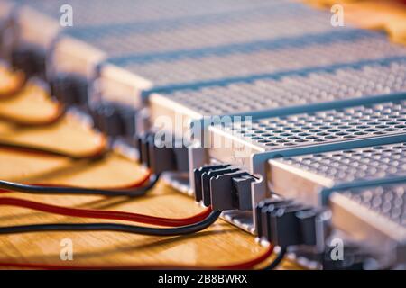 Les boîtiers métalliques en maille d'alimentation et de fils sont sur une table en bois à la production d'ordinateurs de haute technologie. Concept de haute technologie et industriel p Banque D'Images