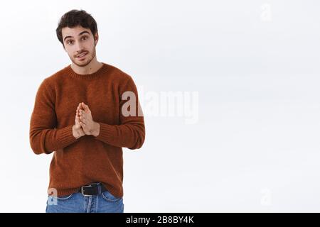 Beau jeune homme plein d'espoir et sincère demandant la faveur, battez les mains dans prier et regarder la caméra, dites s'il vous plaît, essayez faire affaire, besoin d'aide, mendier Banque D'Images