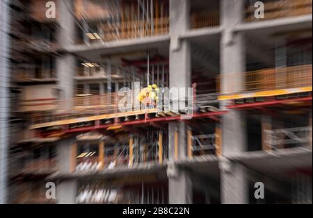 Offenbach, Allemagne. 21 mars 2020. Deux travailleurs de la construction travaillent à des hauteurs élevées sur un grand chantier de construction au Kaiserlei à Offenbach (tourné avec un effet zoom). Crédit: Frank Rumpenhorst/dpa/Alay Live News Banque D'Images