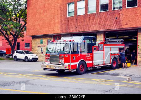 Juin 2018 - Montréal, Canada : immeuble du Service des incendies de Montréal avec camions et pompiers stationnés devant le bâtiment. Banque D'Images