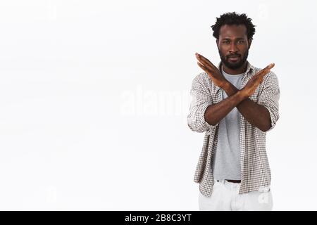 Un jeune homme afro-américain à la barbe réticent et mécontent qui traverse la poitrine, a été déçu par la ruée, refusant ou rejetant quelque chose Banque D'Images