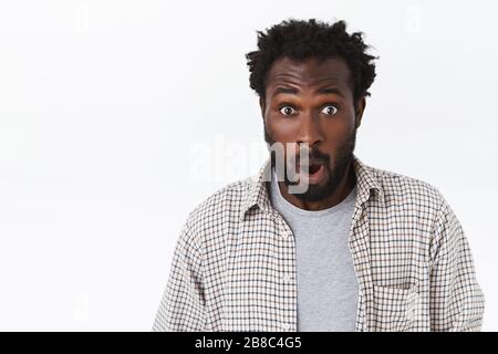 Gros plan portrait beau jeune surpris afro-américain gars, stupéfait, bouche ouverte de l'étonnement et de l'intérêt, l'appareil photo de stare embuscade Banque D'Images