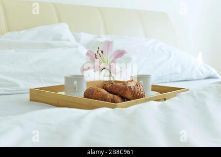 petit déjeuner sucré avec croissant au lit Banque D'Images