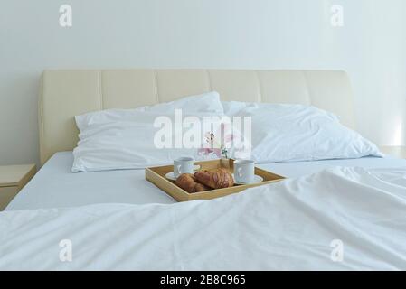 petit déjeuner sucré avec croissant au lit Banque D'Images