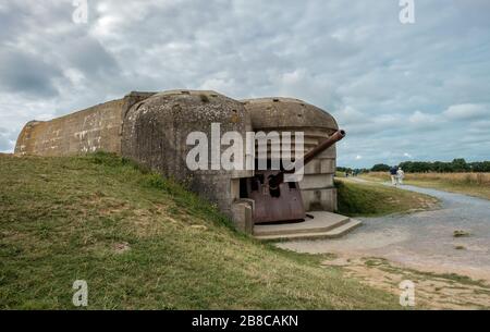 Les touristes visitant la batterie d'armes à feu de la seconde Guerre mondiale de Longues-sur-Mer en Normandie. Banque D'Images