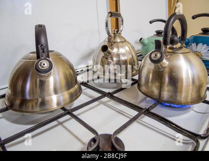 Plusieurs bouilloires sont debout sur le poêle à gaz d'une cuisine commune Banque D'Images