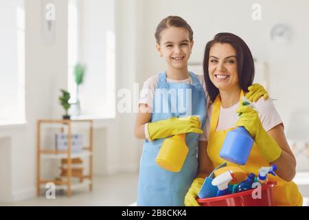 Une famille souriante et heureuse nettoie le salon Banque D'Images