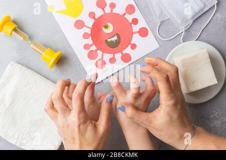 L'enfant et sa mère mains dans le savon effrayer le virus corona dessiné covid-19 lavage des mains avec du savon pour empêcher le concept de virus Banque D'Images