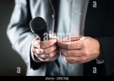 Concept de la droite de la scène. Haut-parleur public nerveux et timide avec microphone. Homme d'affaires peur de donner un discours pour la foule de personnes ou de public. Banque D'Images