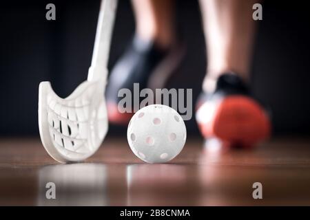 Joueur de floorball en course avec ballon et bâton. Concept de hockey sur sol. Banque D'Images